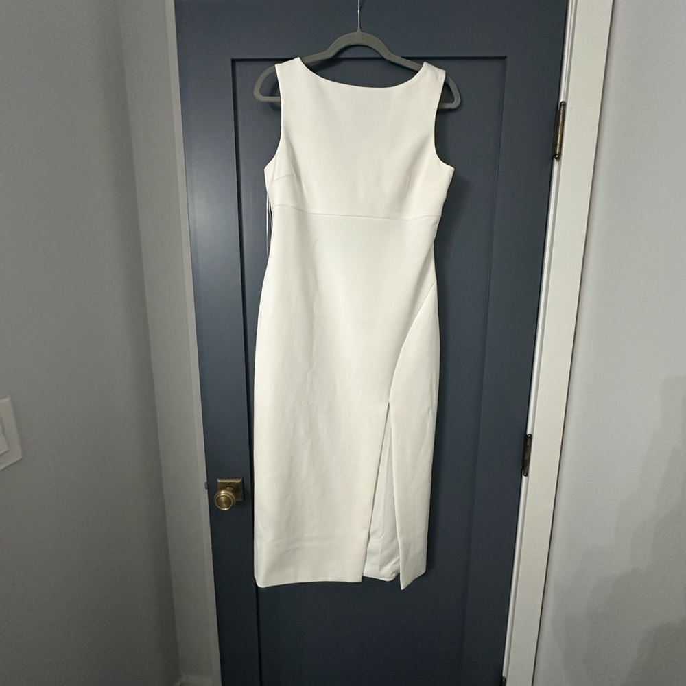 Likely White fitted dress with a front silt and draped pearls on the back.